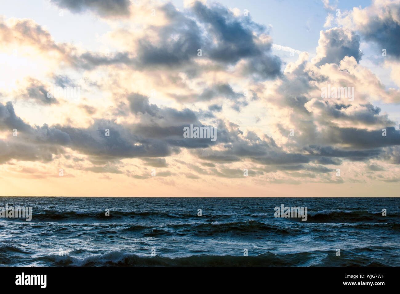 El océano, el agua de mar gruesa con horizonte y nubes durante el atardecer Foto de stock