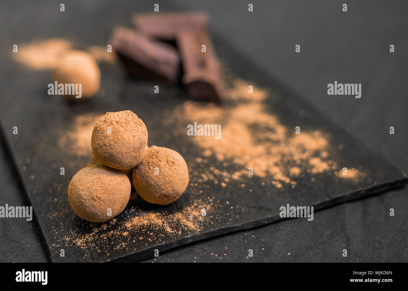 Chocolate Truffle candy recubiertos de cacao en polvo contra el fondo negro. Foto de stock