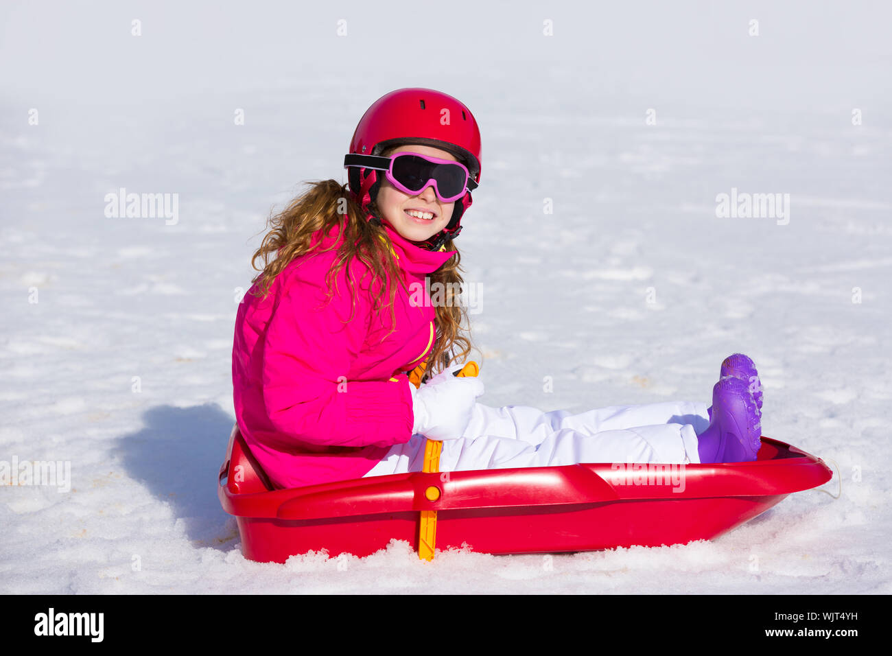 Niño Niña jugando sled en invierno, la nieve con casco ang gafas Fotografía  de stock - Alamy