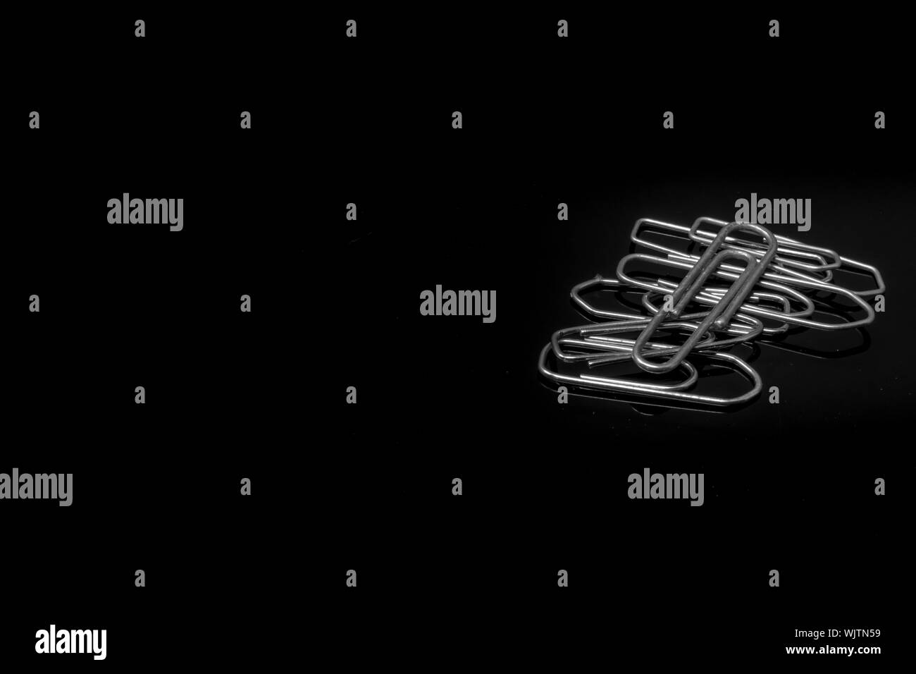 Close-up de clips para papel contra el fondo negro Fotografía de stock -  Alamy
