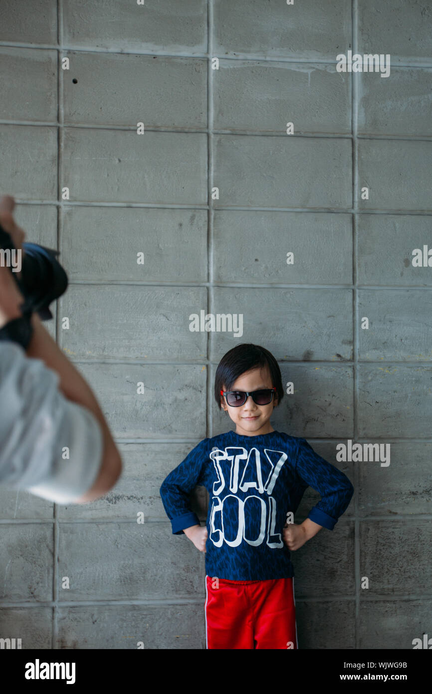 Un hombre fotografiando chico lindo con actitud cool Foto de stock