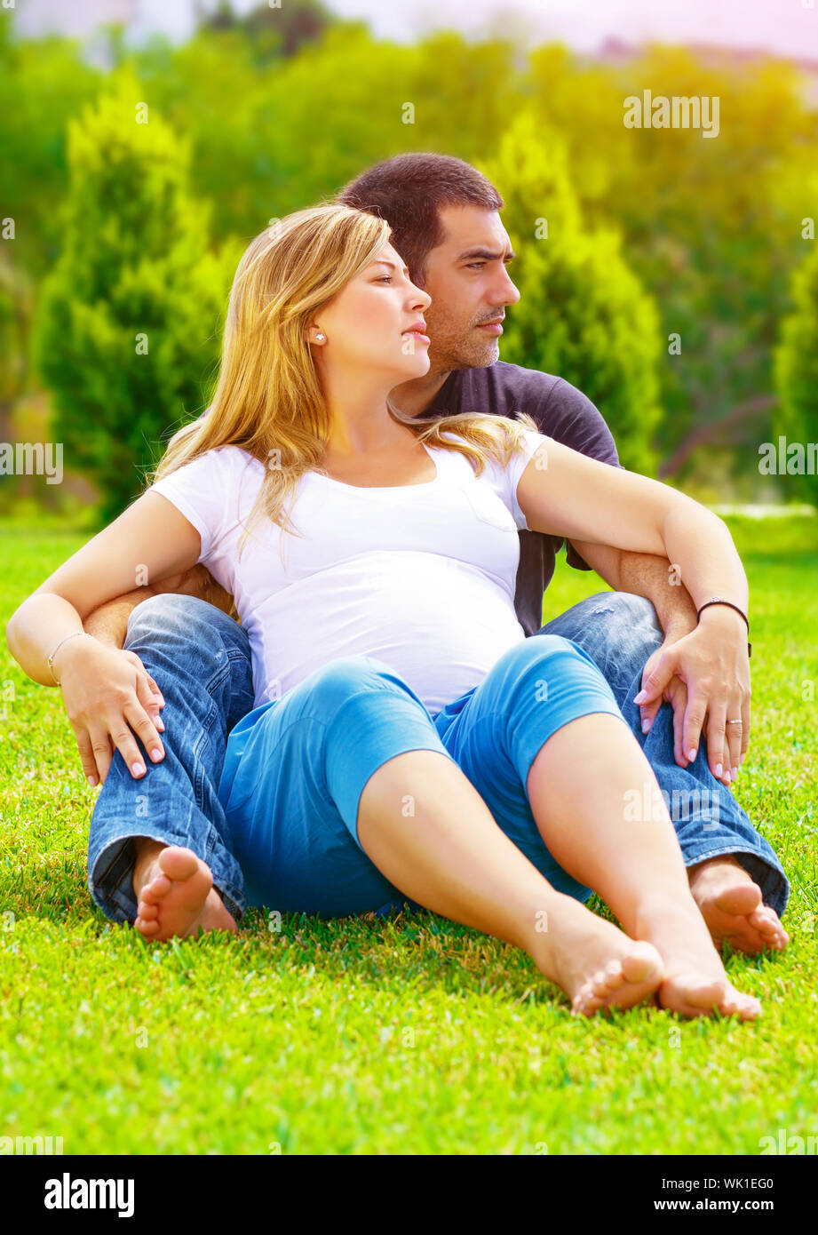 Feliz pareja esperando bebé, linda mujer embarazada con su marido sentado  en el pasto verde campo, disfrutando del verano, el concepto de amor  Fotografía de stock - Alamy