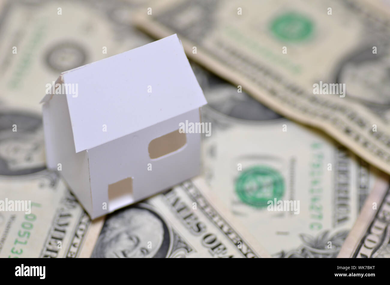 Cerca de la casa modelo y papel moneda que representa la propiedad de la vivienda Foto de stock