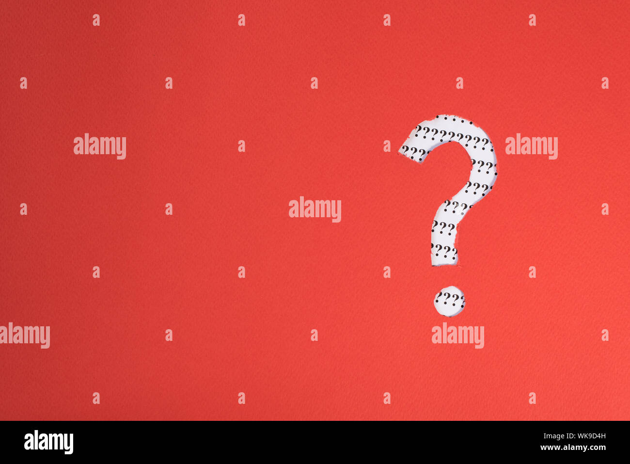 Papel rojo teared a símbolo de interrogación revelando más interrogación sobre papel blanco. Concepto de FAQ, Q&A, buscar riddle e información Foto de stock