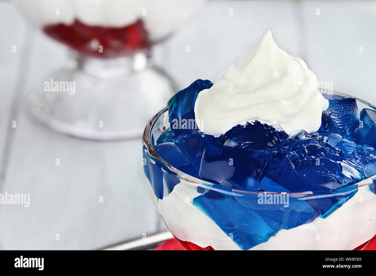 Gelatina de postre en capas de cubos de gelatina roja y azul con blanco  esponjoso crema batida para el 4 de julio de vacaciones. Profundidad de  campo Fotografía de stock - Alamy