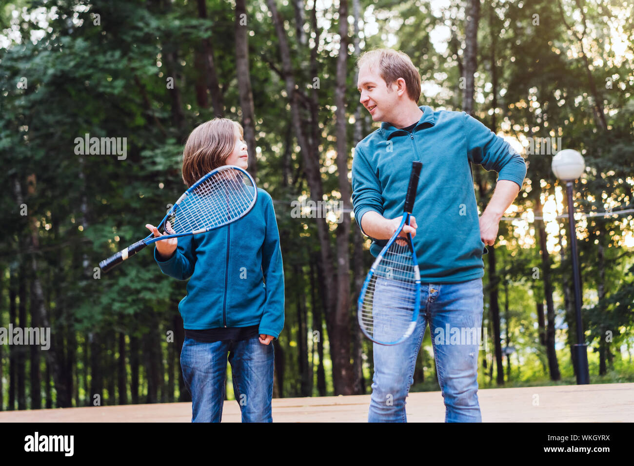 Padre enseña al hijo a jugar al bádminton en el parque. Fin de semana para dos personas. Foto de stock