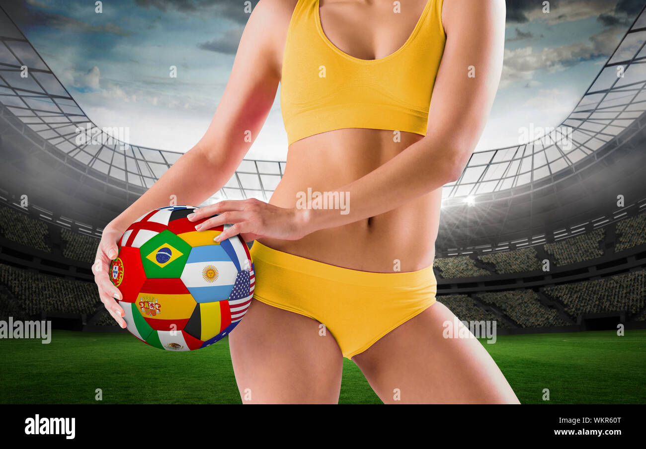 Colocar chica en bikini amarillo sosteniendo la bandera contra el gran  estadio de fútbol fútbol con luces Fotografía de stock - Alamy