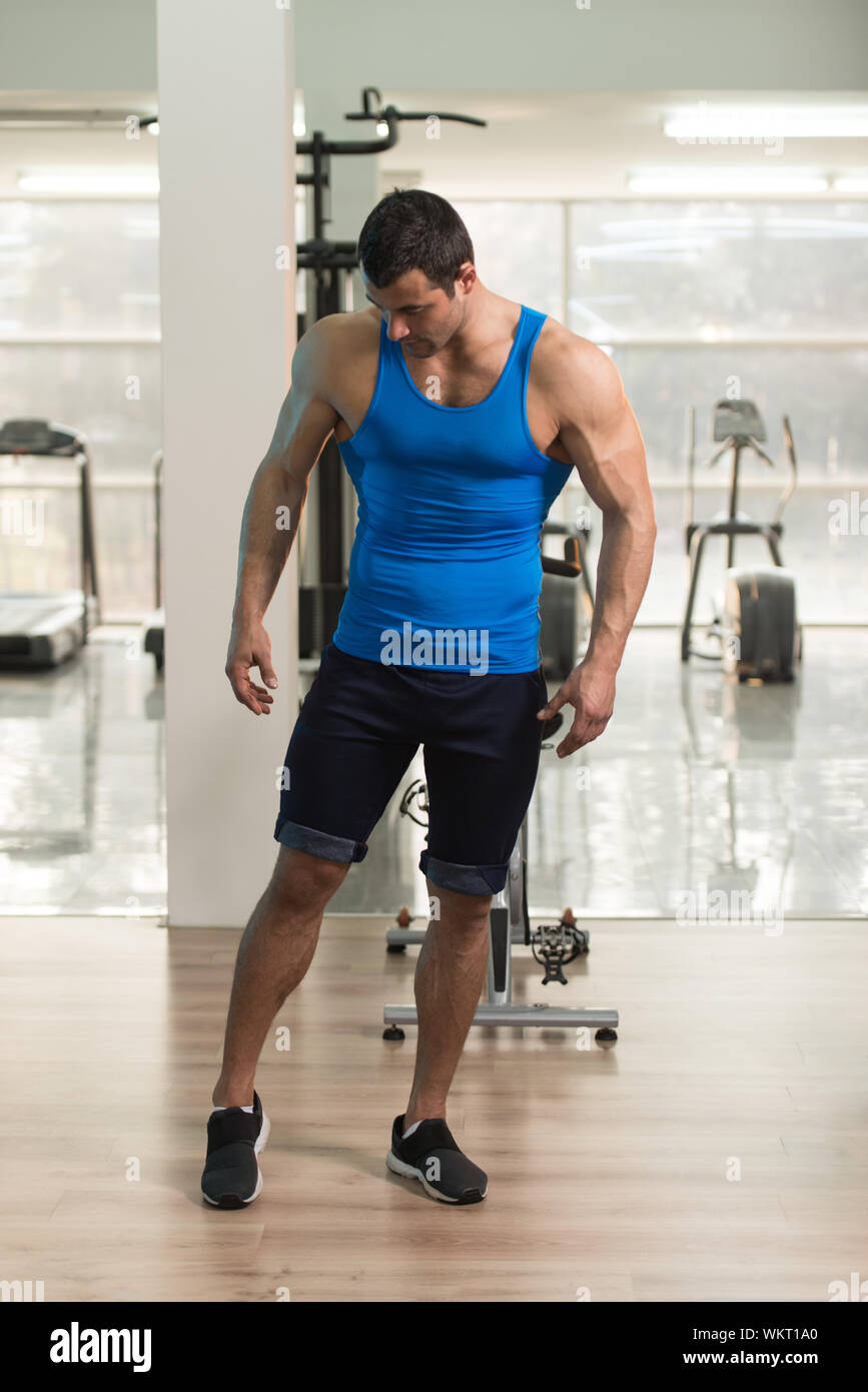 Musculoso hombre vestido con chaleco de pie en el gimnasio Fotografía de  stock - Alamy