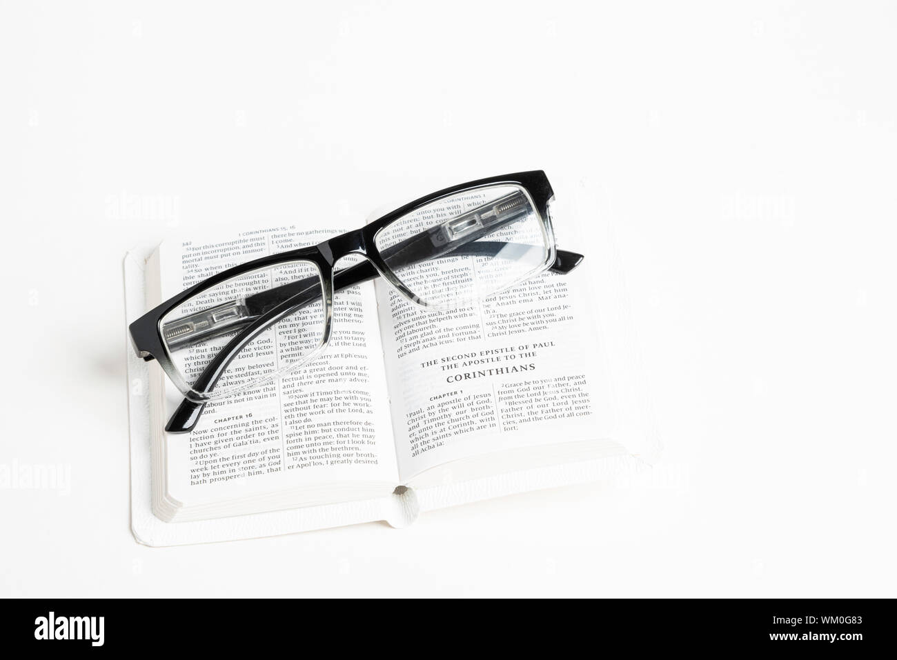 Una Biblia de bolsillo portátil blanco abierto con un par de gafas de  lectura clara establecida sobre fondo blanco liso Fotografía de stock -  Alamy