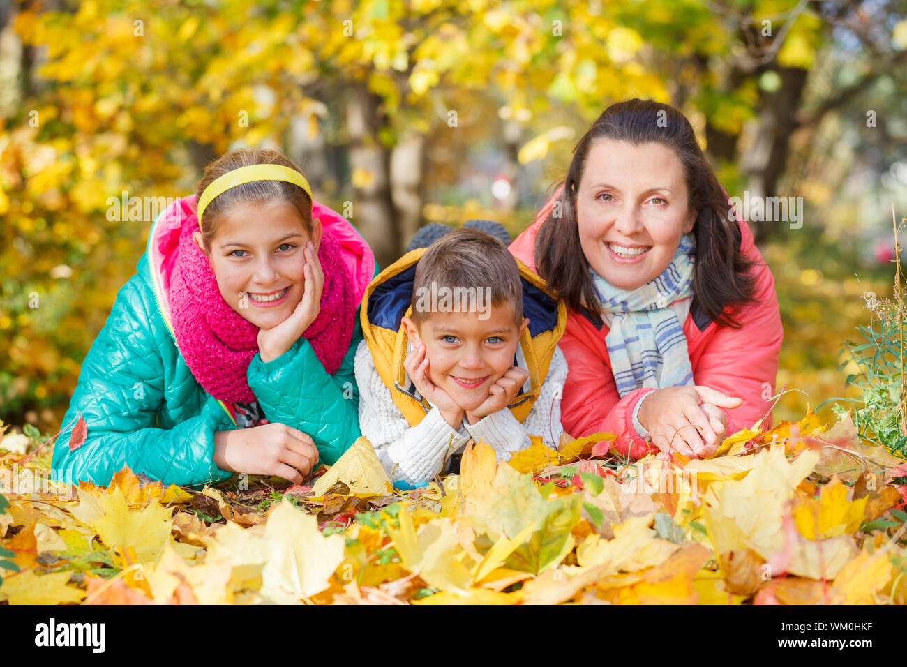 Familia Feliz relajante parque en otoño la madre y sus hijos se diviertan en el parque