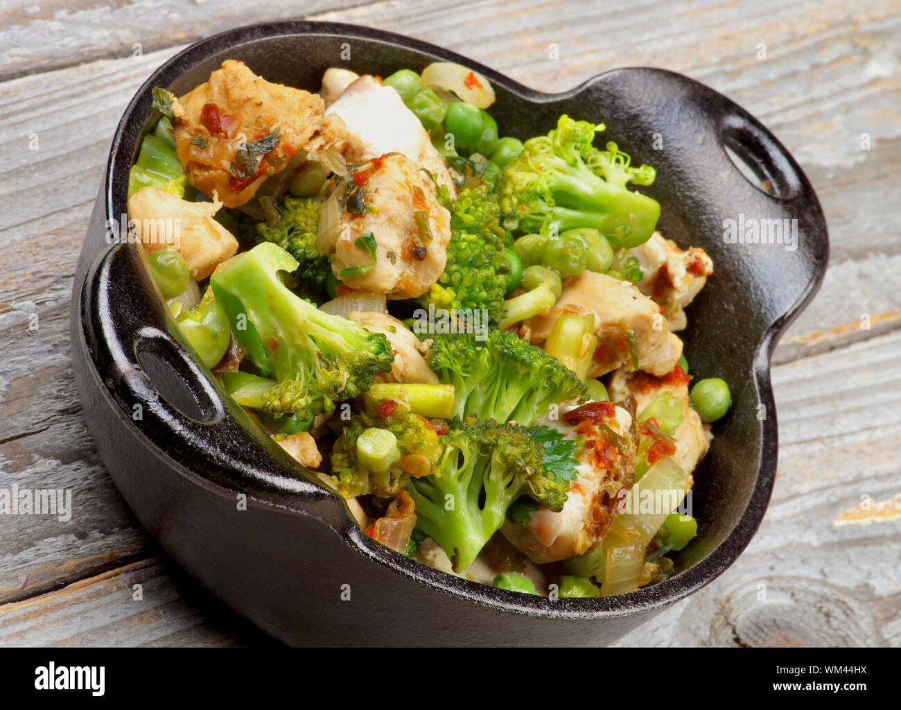 Estofado de Pollo casero con brócoli, pimiento y arveja en perola negra closeup sobre fondo de madera rústica Fotografía de stock - Alamy Estofado de Pollo casero con brócoli, pimiento y arveja en perola negra closeup sobre fondo de madera rústica Fotografía de stock - Alamy