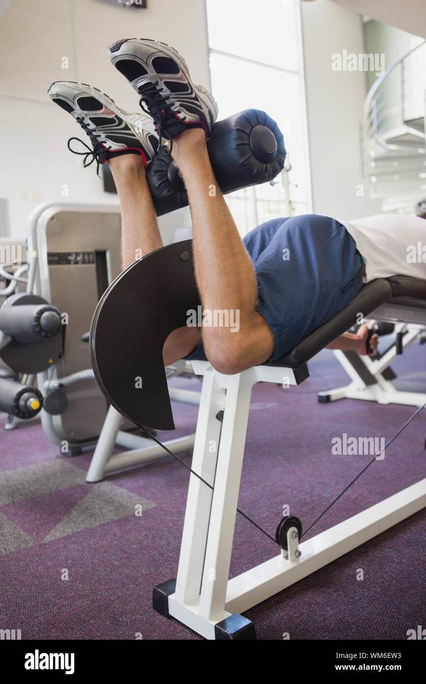 Colocar el hombre usando los pesos de la máquina para piernas en el  gimnasio Fotografía de stock - Alamy