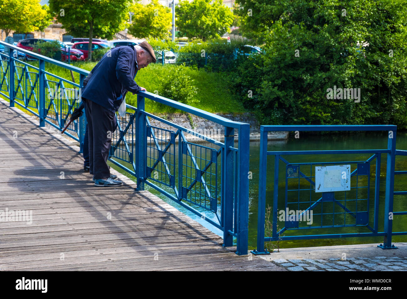 Niort, Francia - 11 de mayo de 2019: el anciano en un puente sobre un río de Sevres, en la parte vieja de la ciudad de Niort, Deux-Sevres, Francia Foto de stock