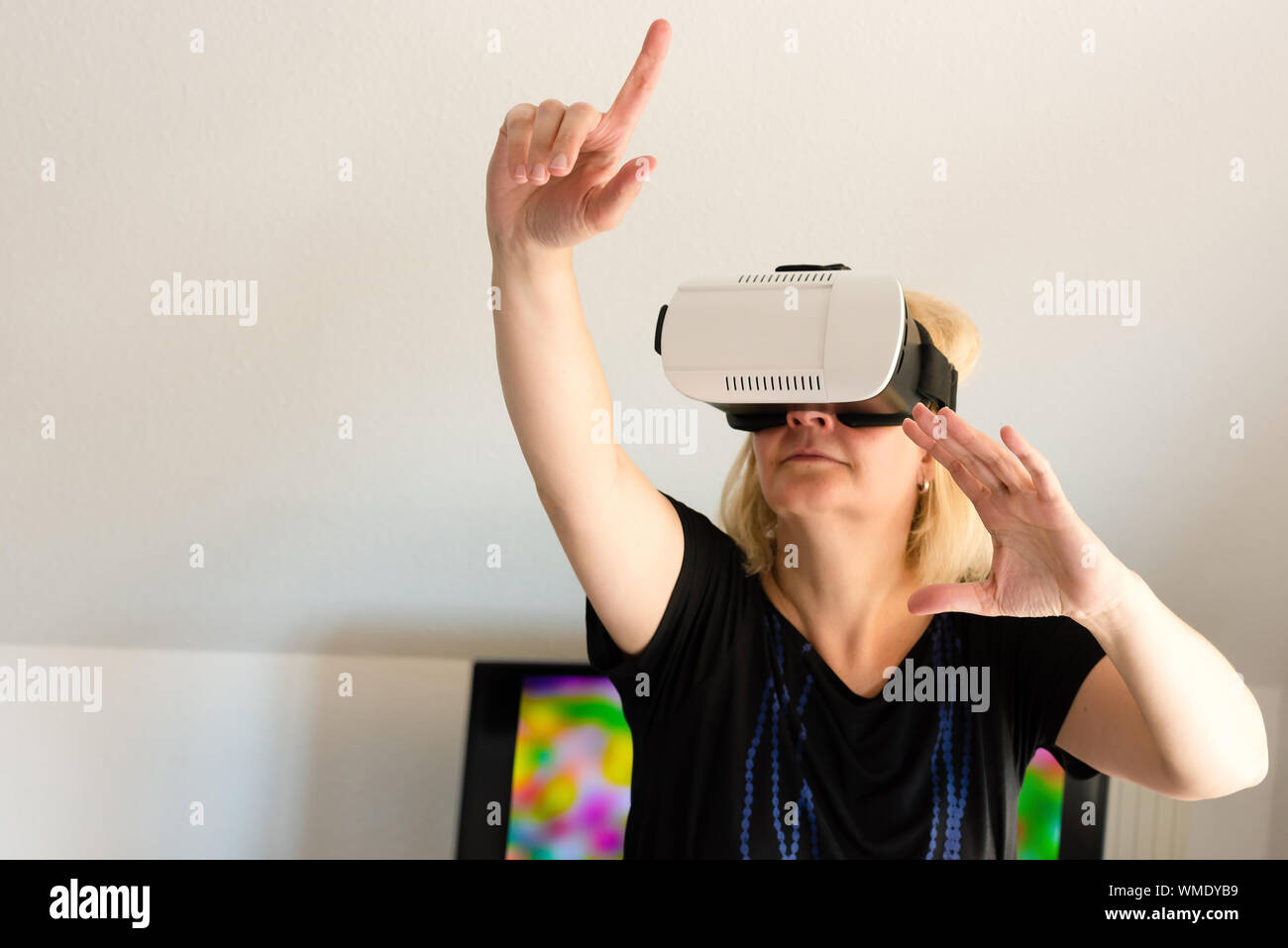 Mujer de mediana edad que buscan a través de gafas de realidad virtual Foto de stock