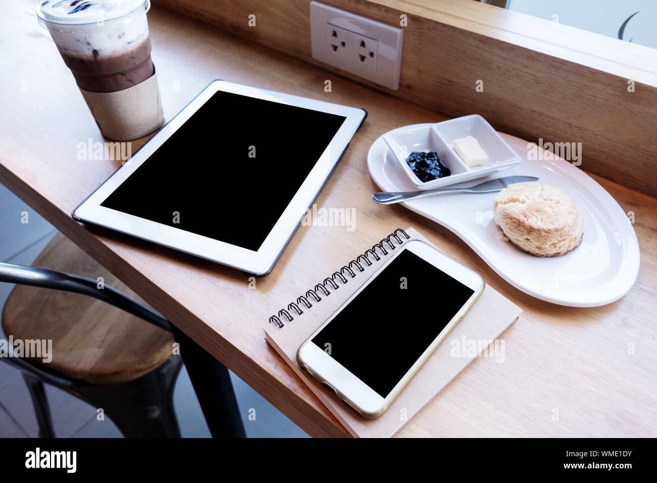 Teléfono inteligente con un café en la mesa del café Foto de stock