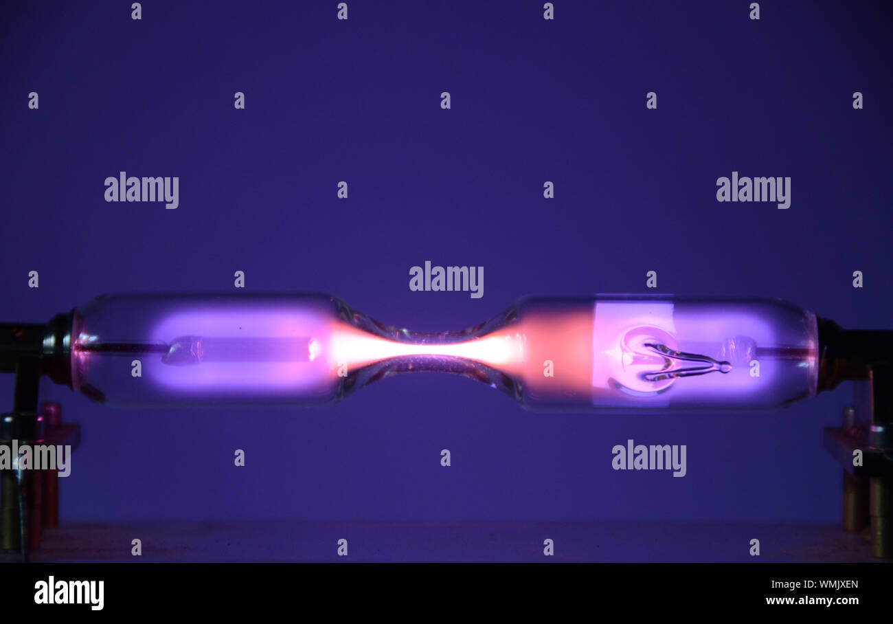 El gas inerte helio (He) visto en un tubo de descarga emite luz debido a un eléctrico Fotografía de stock - Alamy