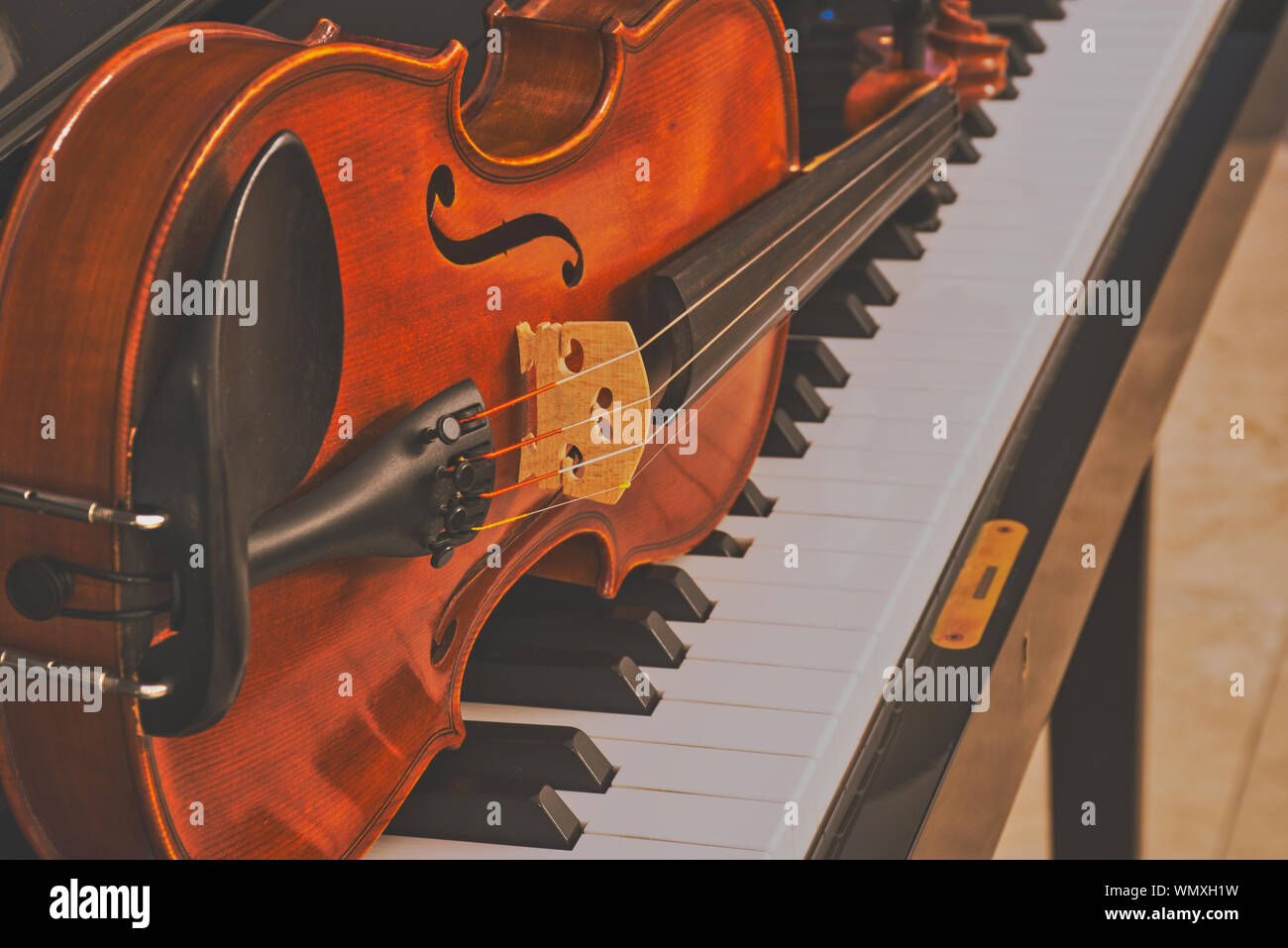El violín está tumbado sobre un piano, cerrar la imagen en color en estilo  mate Fotografía de stock - Alamy