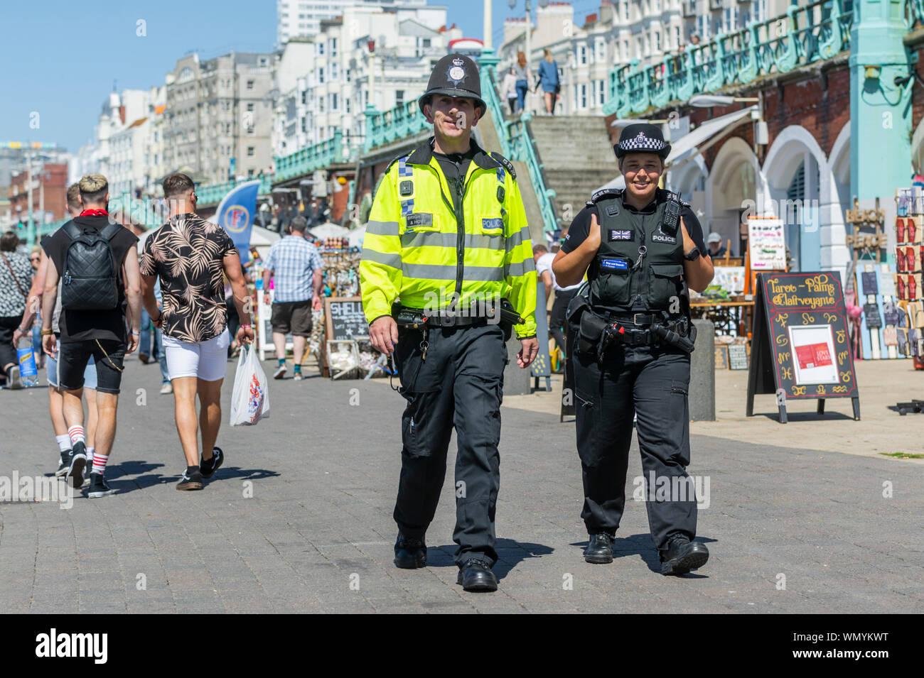 La presencia de la policía. Policías patrullando el paseo marítimo en verano en Brighton, East Sussex, Inglaterra, Reino Unido. Patrulla de la policía en Brighton Foto de stock