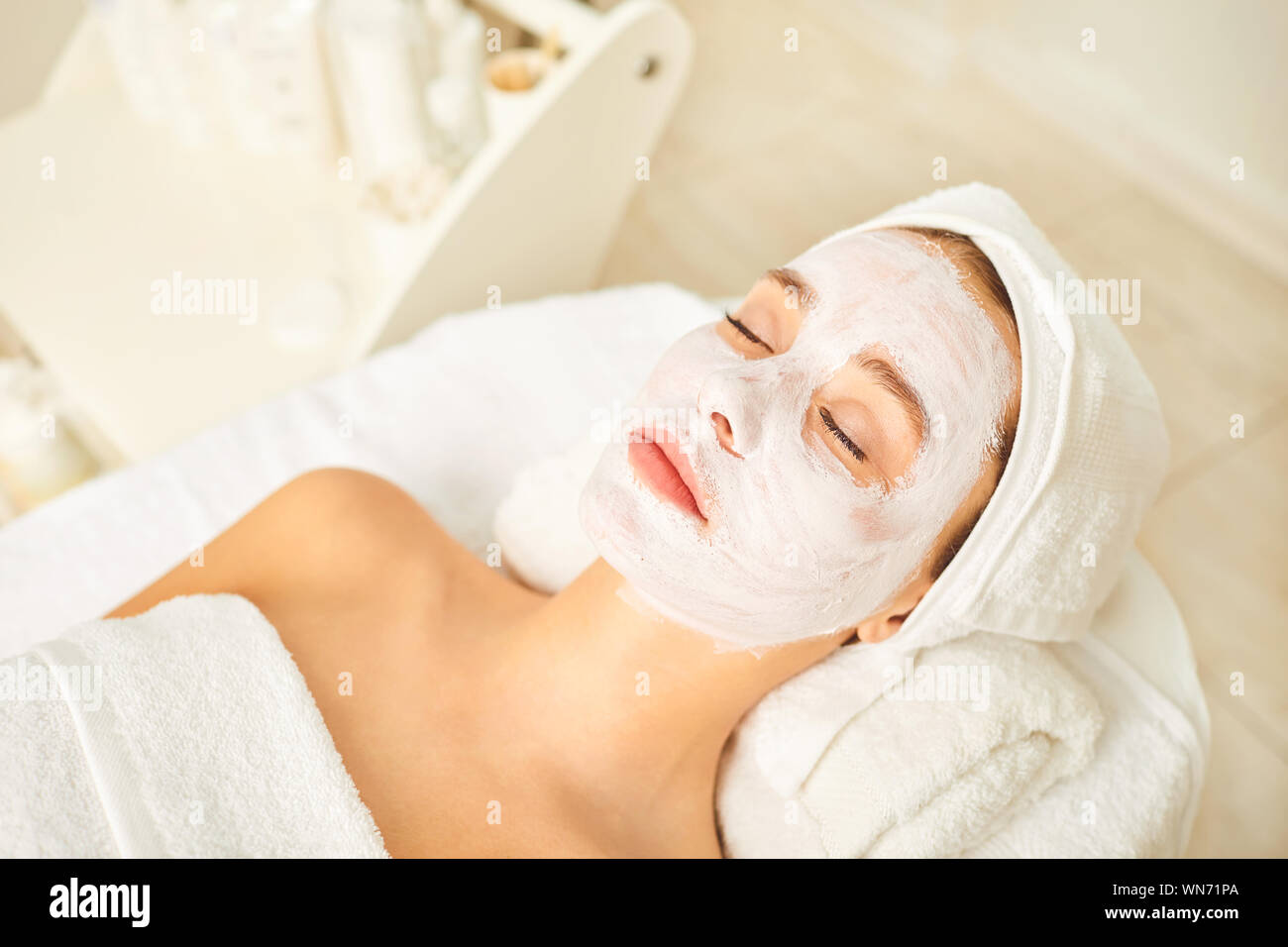 Máscara Cosmética en la cara de una mujer en el salón spa. Foto de stock