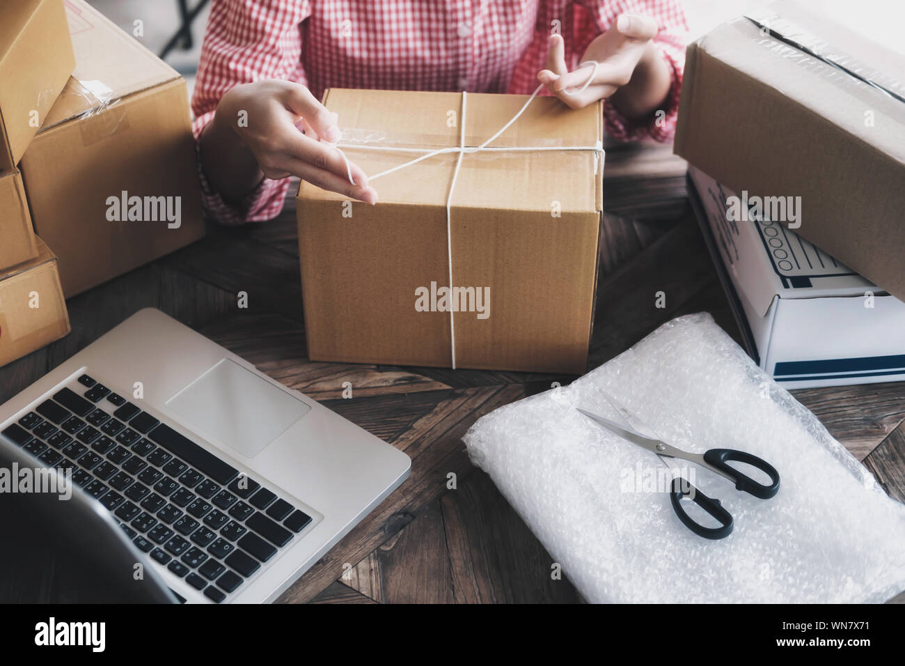 Sección media de la persona en la mesa Caja de cartón de embalaje en casa  Fotografía de stock - Alamy