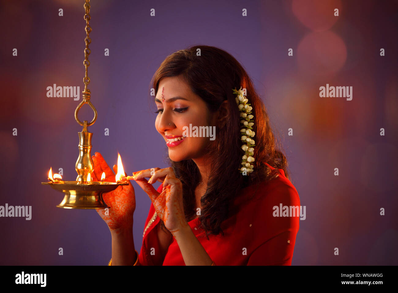 Hermosa mujer india en Rojo Sari Diya Iluminación durante el Diwali Foto de stock