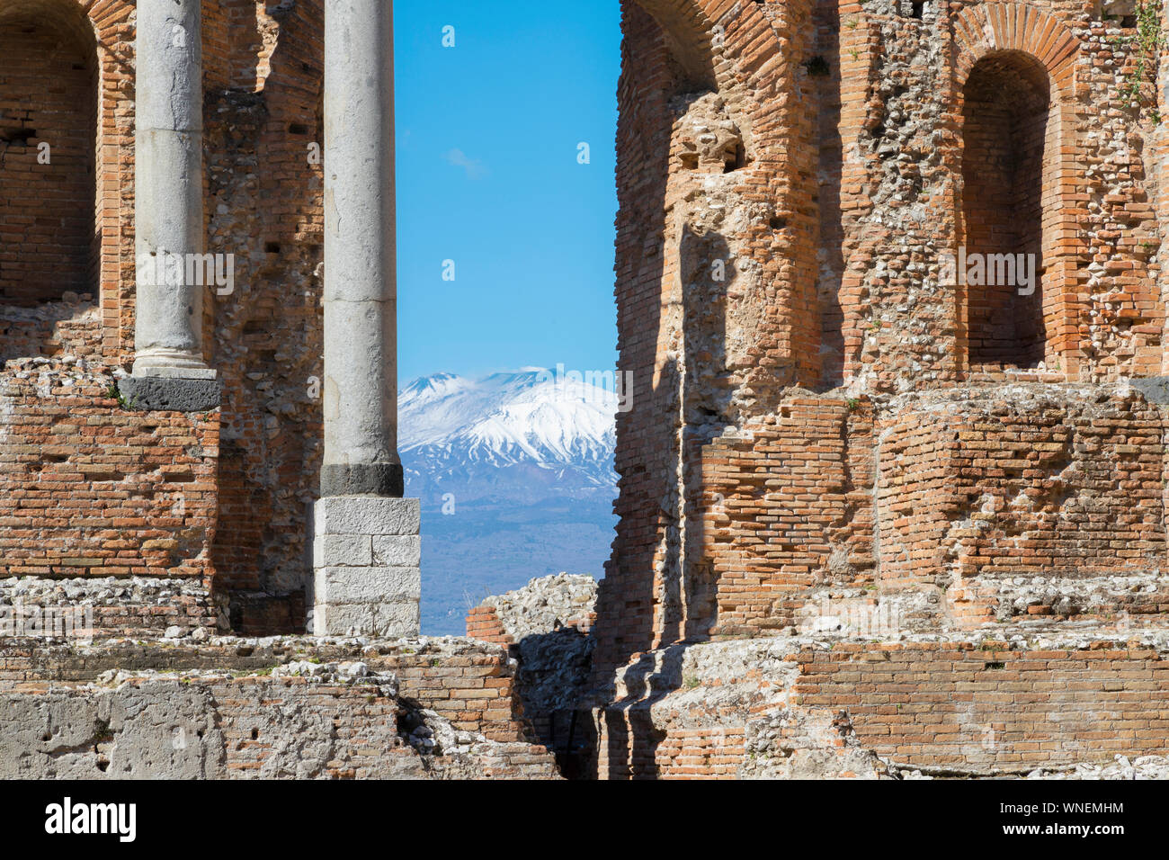Taormina - el teatro griego con el Mt. Volcán Etna y a la ciudad. Foto de stock