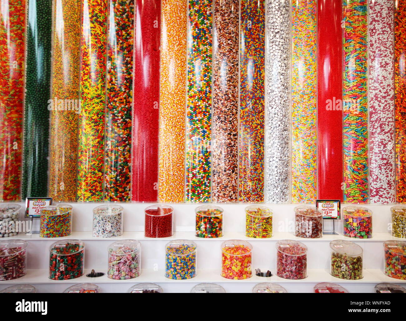 Coloridos dulces en tubos y recipientes transparentes verticales Foto de stock