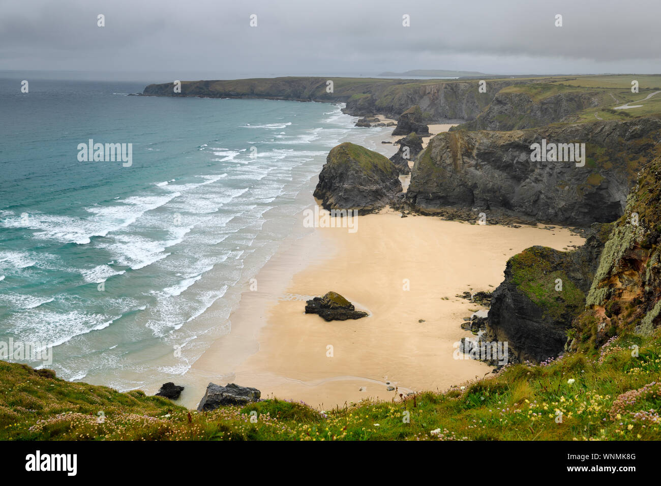 Los fuertes vientos y lluvias en pasos Bedruthan pilas al mar y la playa de arena en el Mar Céltico costa de Cornwall Inglaterra Foto de stock