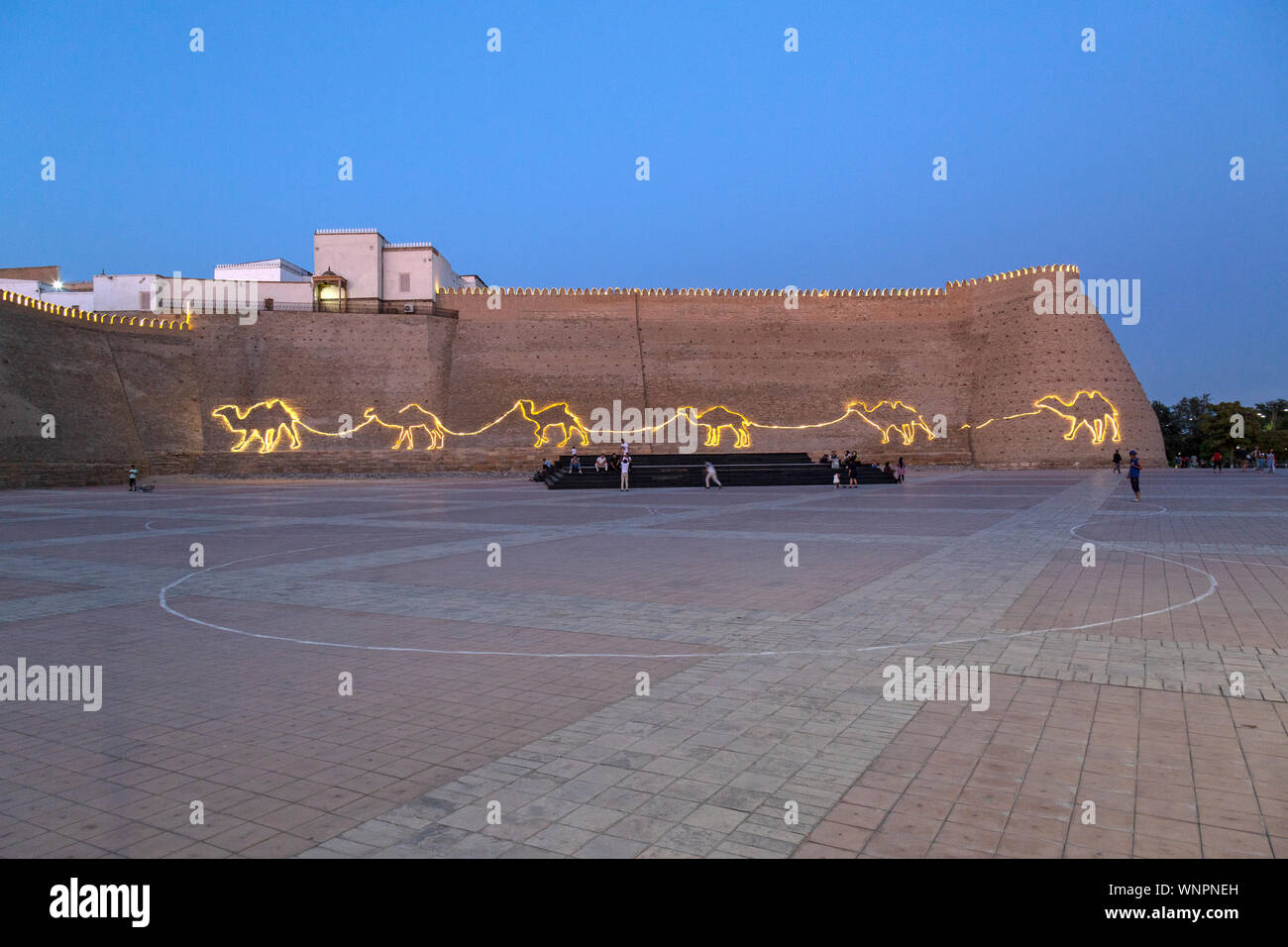 Earl.y noche fotografía de la ciudadela de Ark en Bukhara, Uzbekistán,  mostrando la plaza, y luces en la forma de un tren de camellos en la ruta  de la seda Fotografía de