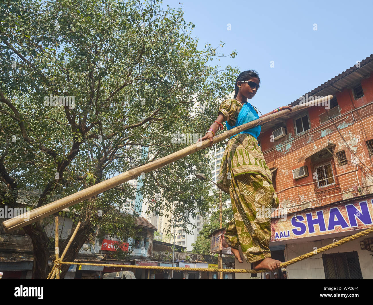 Una joven en Mumbai, India, con espectáculos impenetrable equilibrio sobre una cuerda floja, en una denominada "tamasha' o improvisados circo callejero Foto de stock