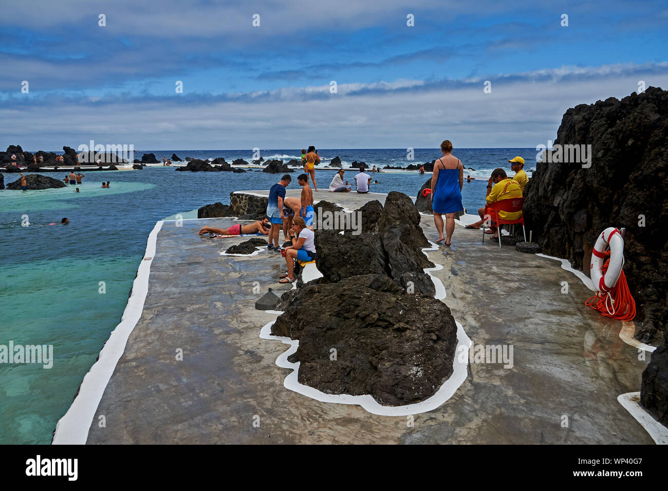 Porto Moniz, Madeira y turistas disfrutando del piscines, piscinas naturales creadas por las formaciones de lava y alimentado por el Océano Atlántico. Foto de stock