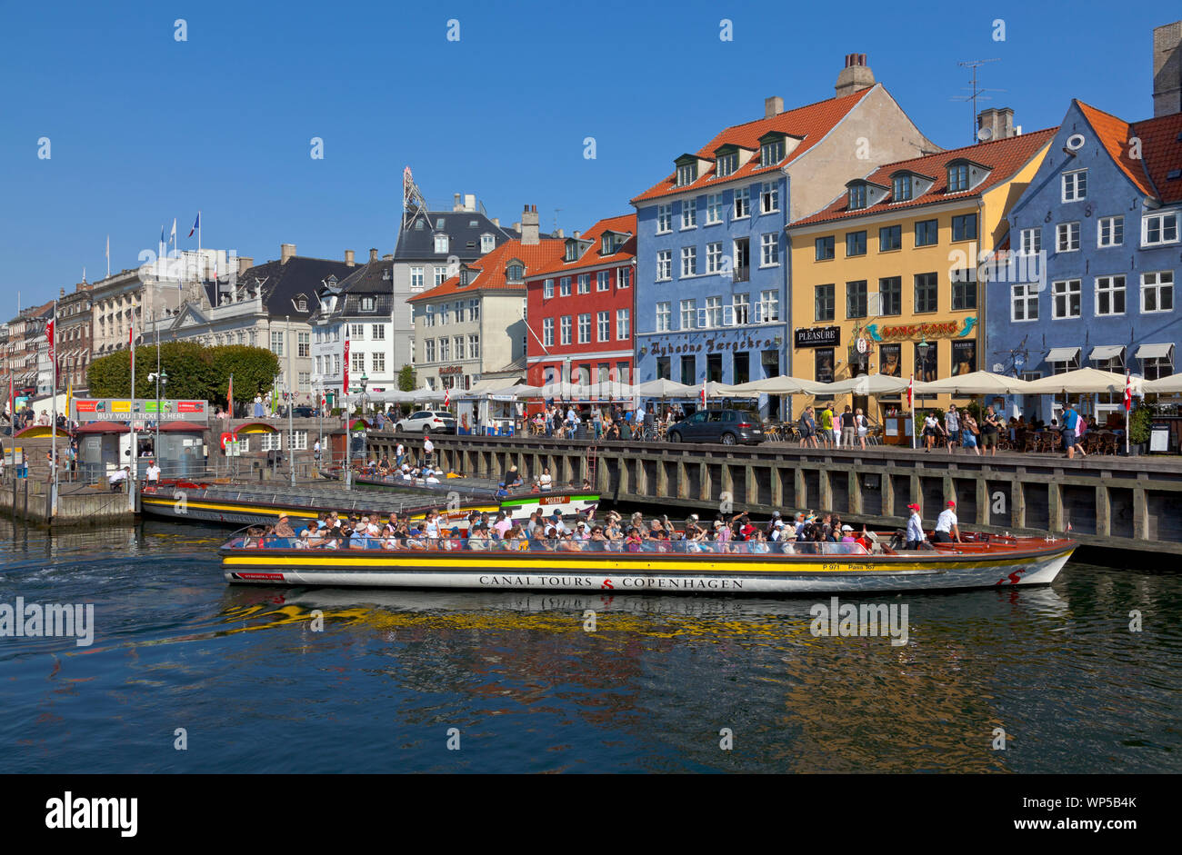 Excursión en barco crucero por el canal comenzando desde el extremo del canal de Nyhavn en Kongens Nytorv moviendo alon las hermosas casas antiguas de colores brillantes a lo largo del canal. Foto de stock