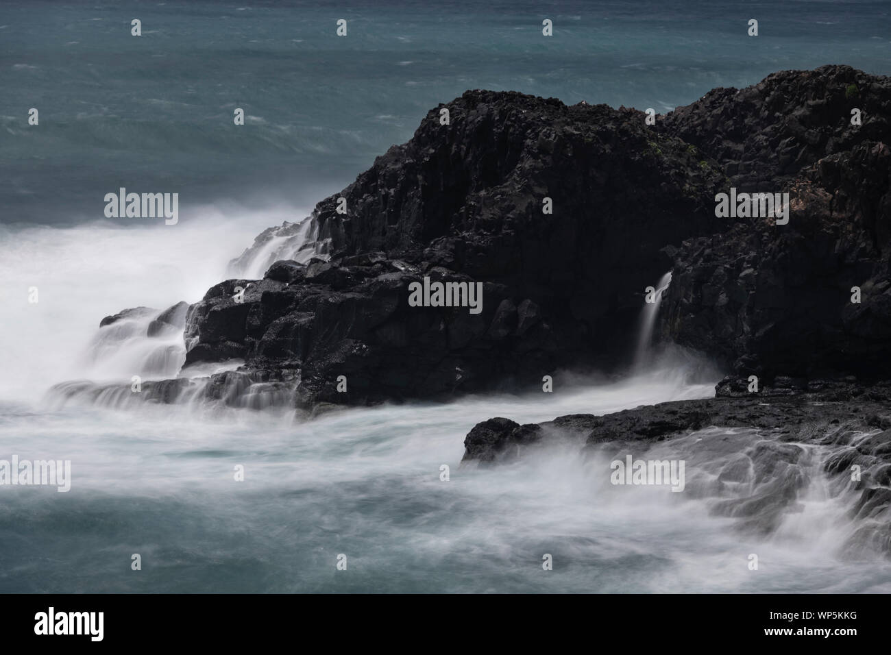 El mar embravecido con una imagen de obturador lento de la marea golpeando la lava volcánica litoral de Sao Miguel. La isla de São Miguel (Portugués para San Miguel, Portu Foto de stock