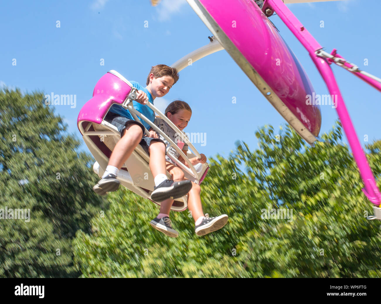 MATTHEWS, NC (USA) - 31 de agosto de 2019: Dos niños disfrutan de un paseo de carnaval en el 'Manual' Viva atthews festival comunitario. Foto de stock