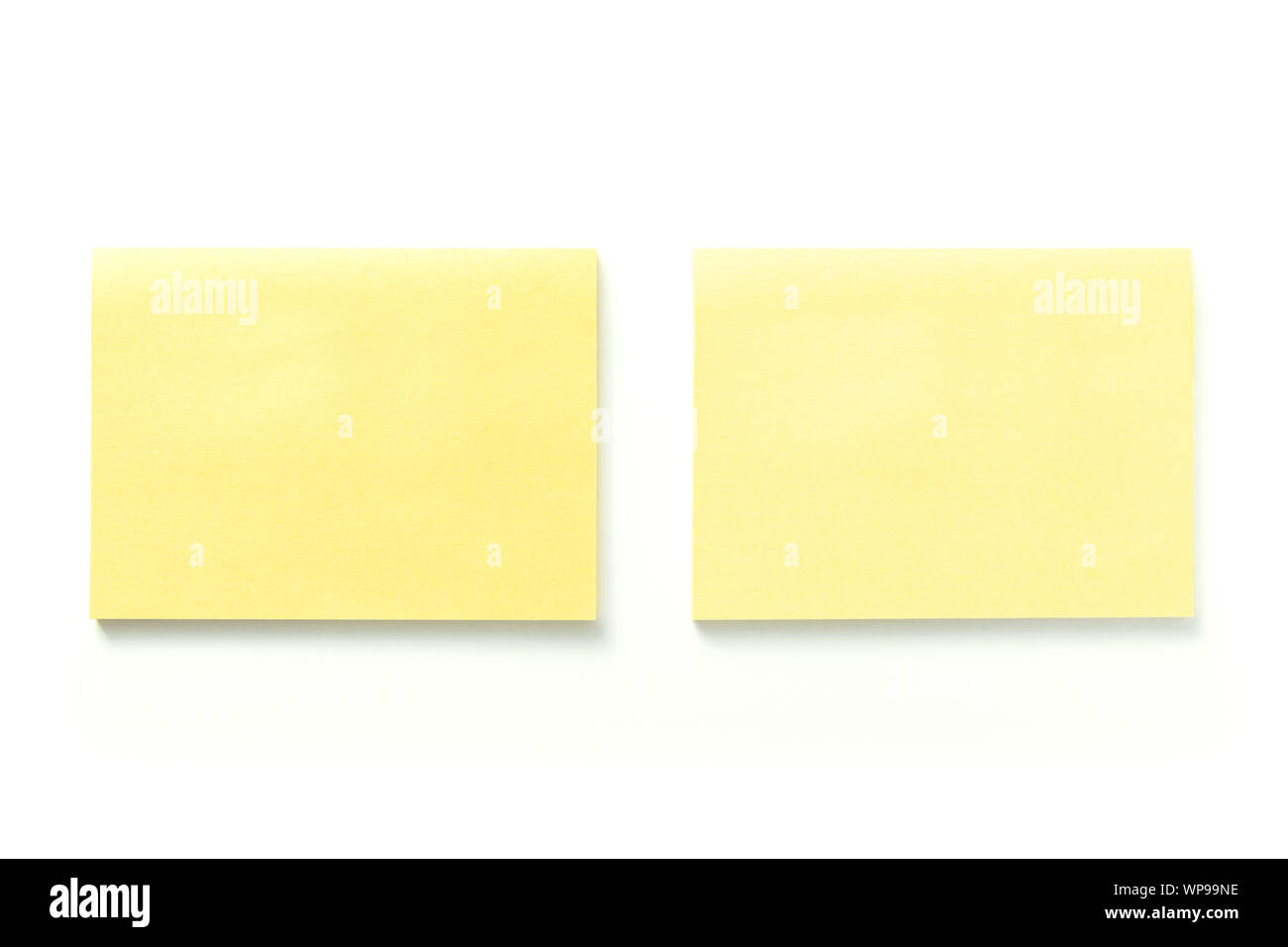 Dos notas adhesivas amarillas en blanco con sombra aislado sobre fondo blanco. Foto de stock