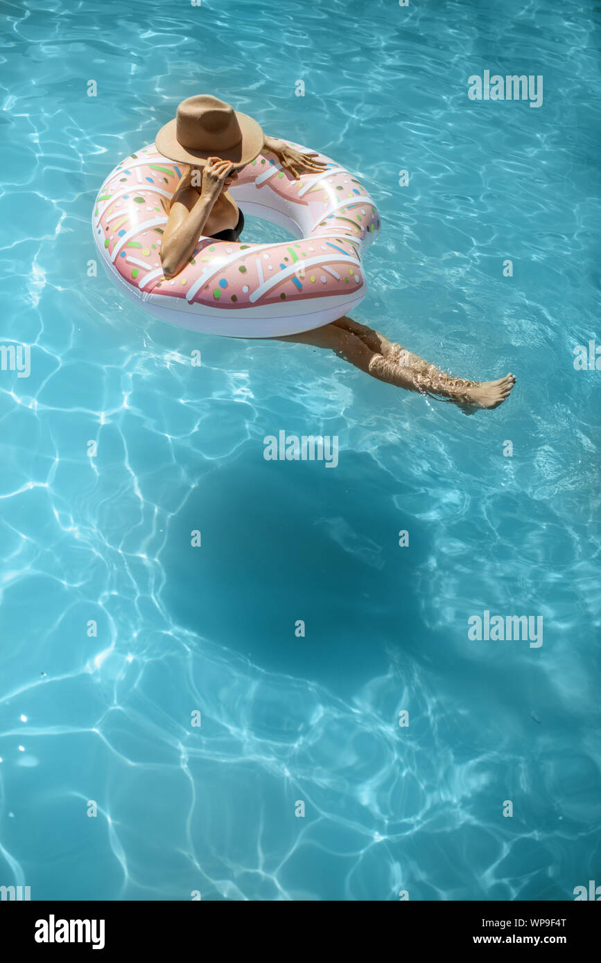 Mujer en traje de baño y gorro de natación con anillo inflable en forma de  un donut en la piscina de agua, vista desde arriba Fotografía de stock -  Alamy