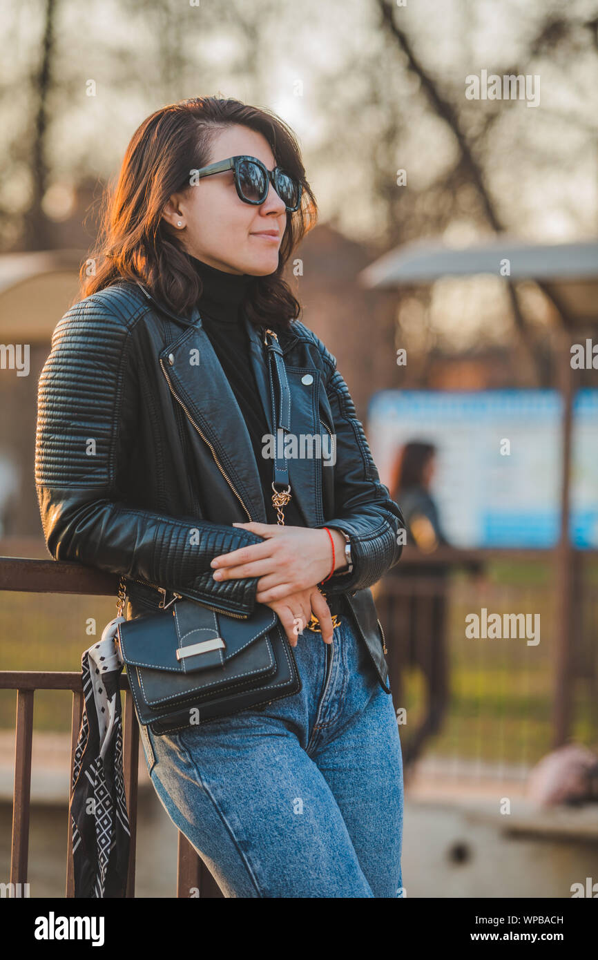 Muy de moda mujer joven posando en jeans y chaqueta de cuero