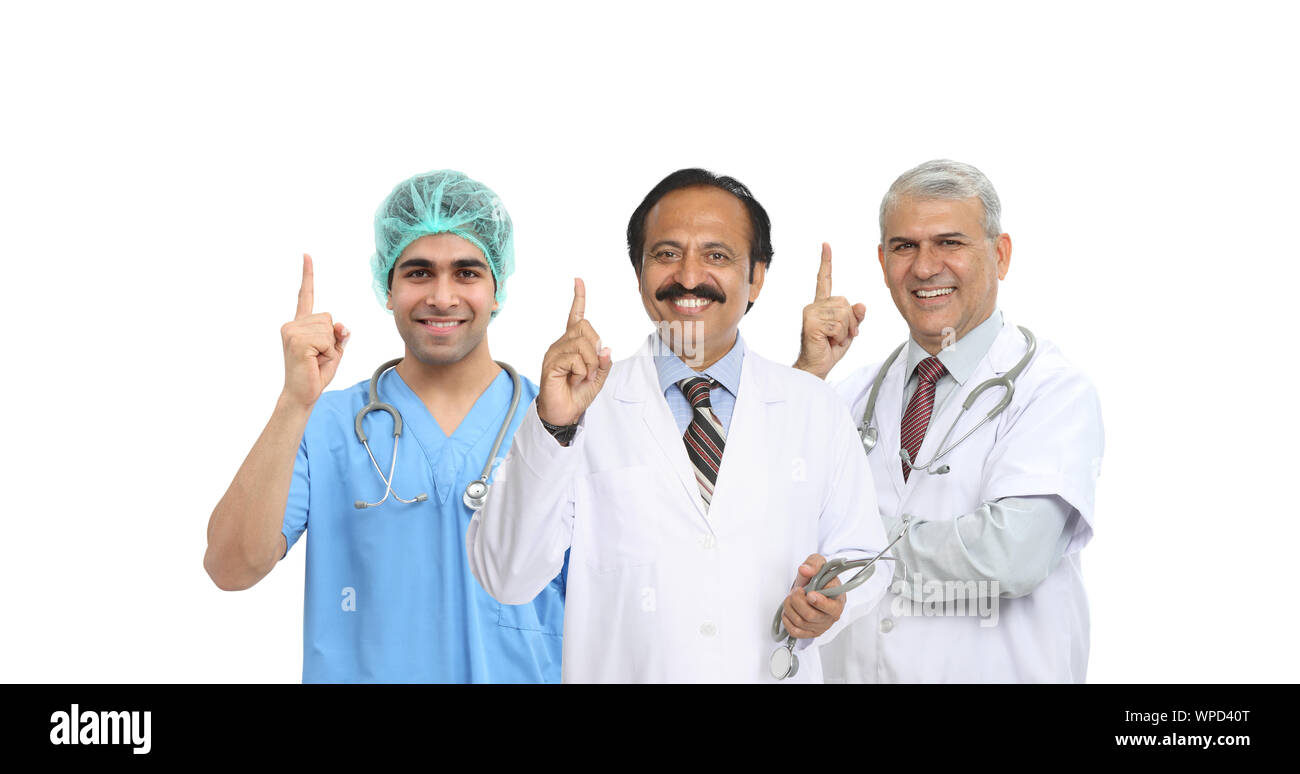 Retrato de un grupo de médicos confiados que apunta hacia arriba Foto de stock