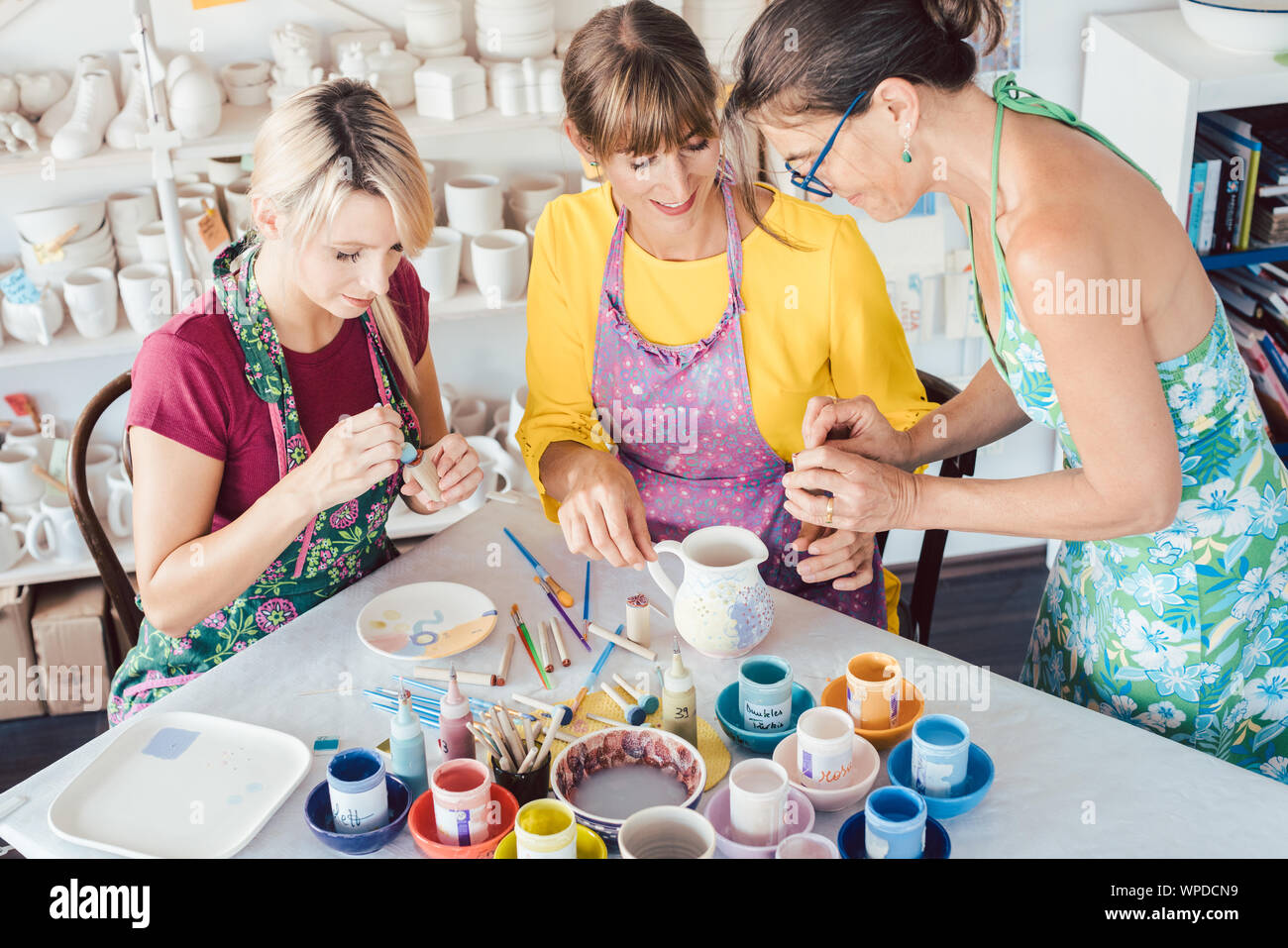 Profesor en el taller de mujeres mostrando cómo pintar self-made platos Foto de stock