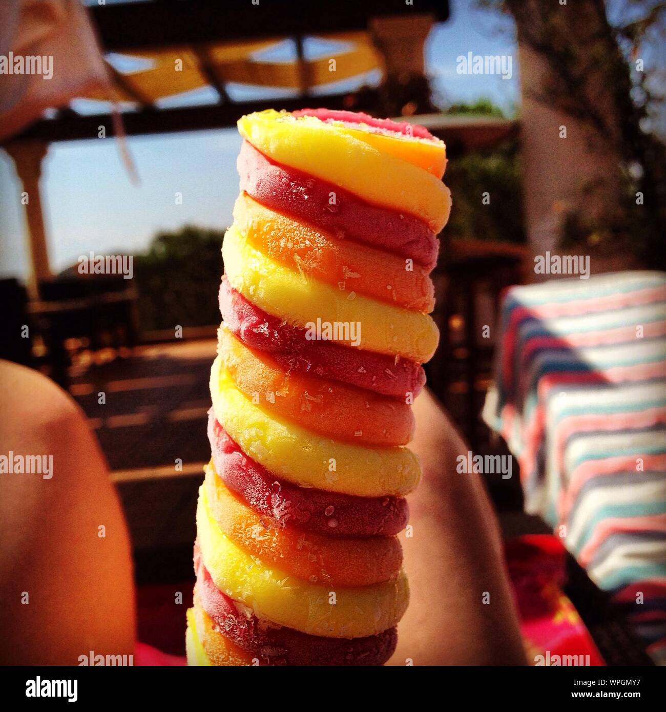 Imagen recortada de persona con coloridos Ice Lolly afuera Foto de stock