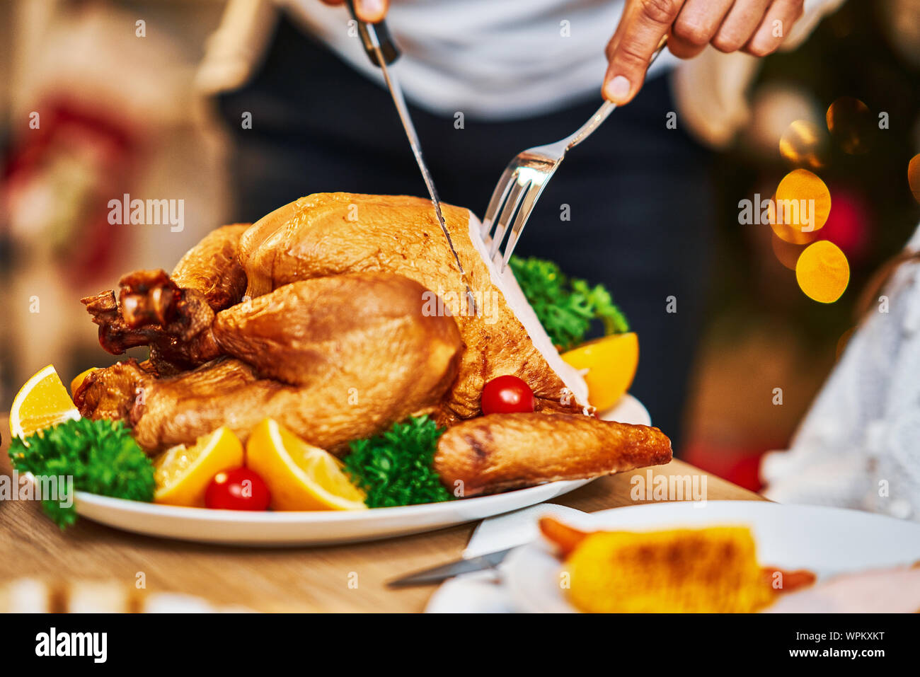 Familia celebrando el Día de Acción de Gracias. Se centran en la mesa y platos Foto de stock