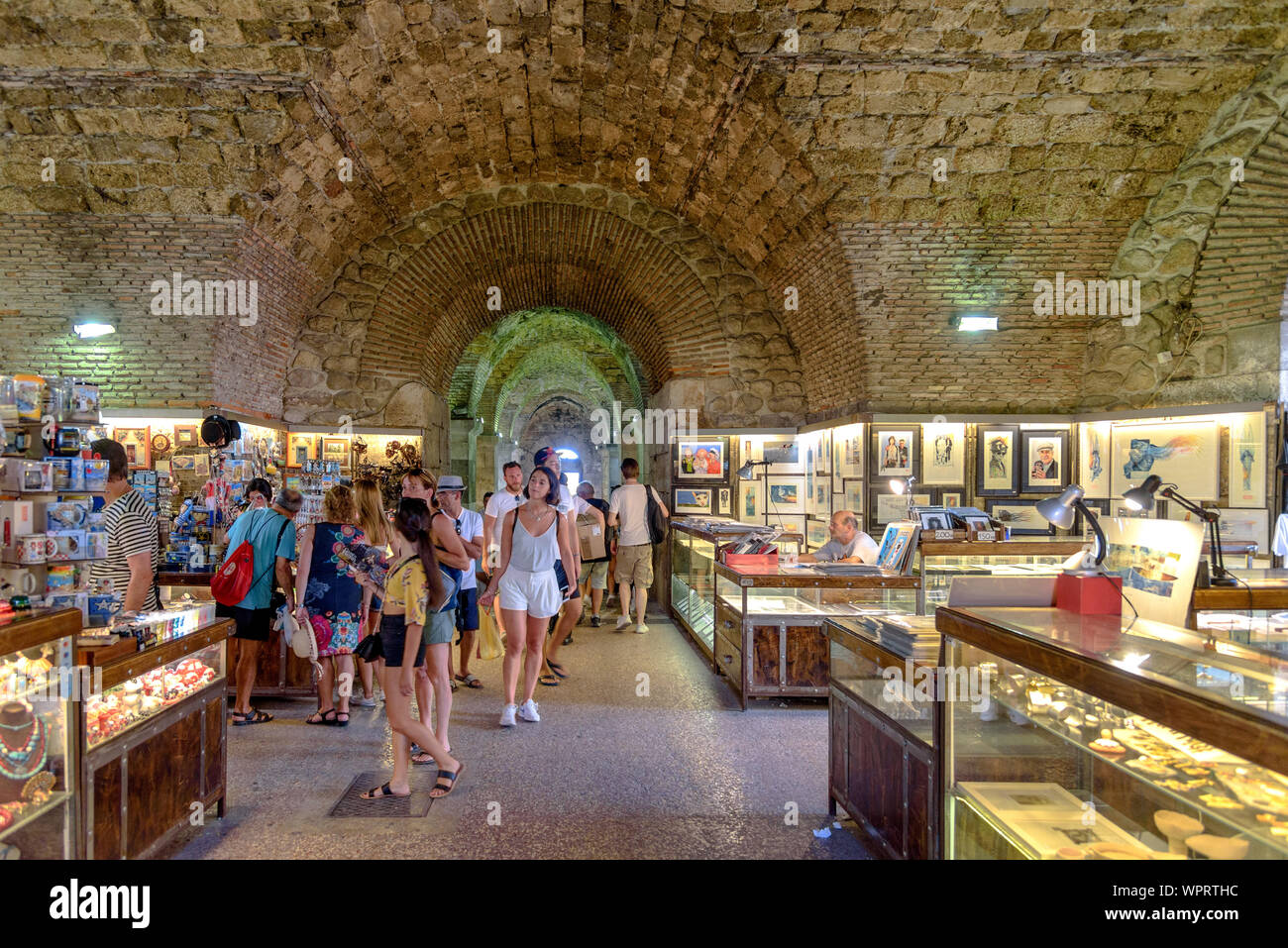 Los turistas de compras en el mercado que existe en el sótano del Palacio de Diocleciano en Split, Croacia Foto de stock