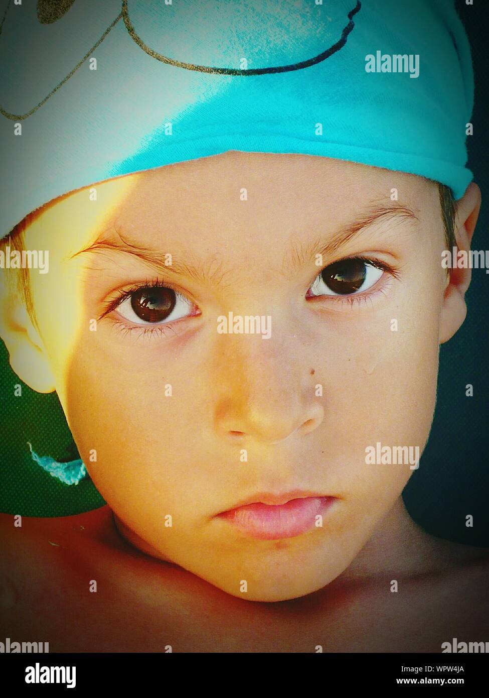 Close-up retrato de graves Turquesa niño usando sombreros Foto de stock