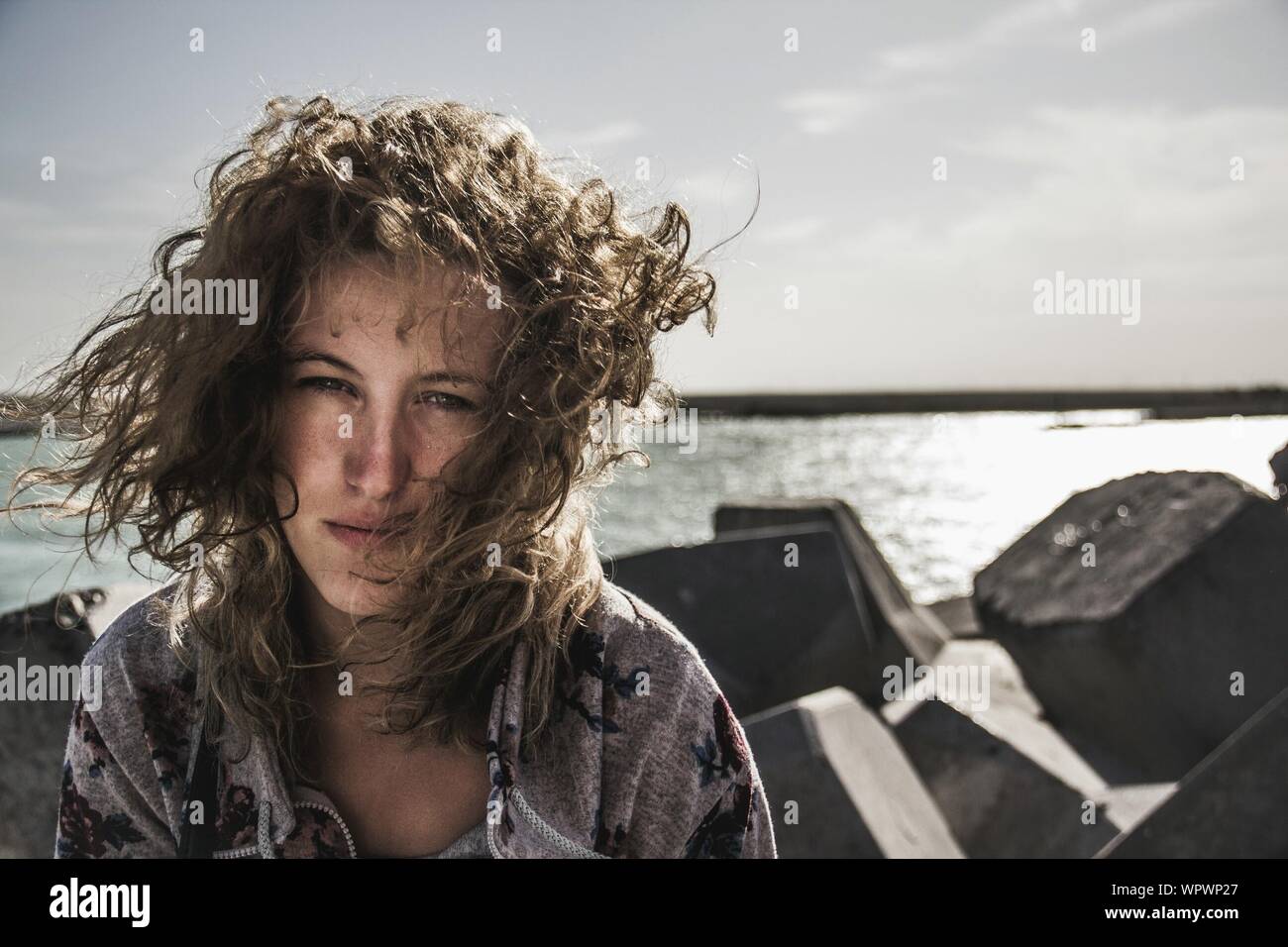 Retrato de mujer joven durante el viento en la playa Foto de stock