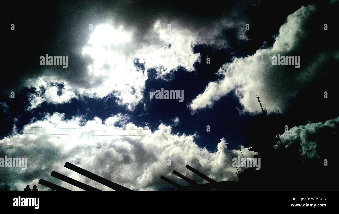 Ángulo de visión baja de silueta acorazado contra el cielo nublado Foto de stock