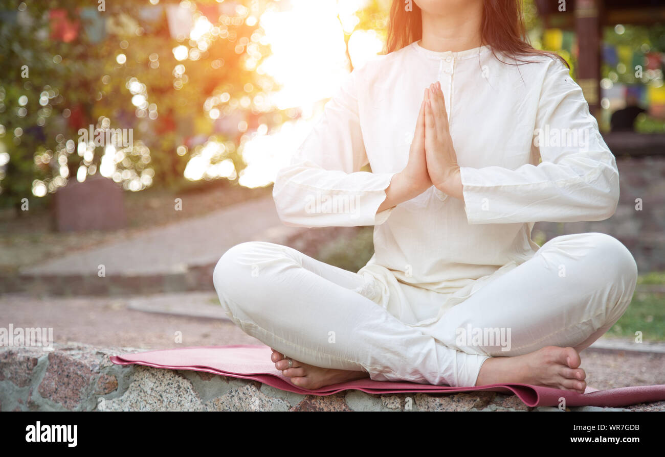 Cerca de una mujer meditando en un parque. Yoga Retreat. Foto de stock