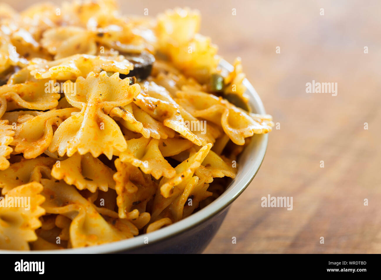 Tazón de pajarita cocido o Pasta Farfalle pasta fresca salsa pesto, cerrar Foto de stock