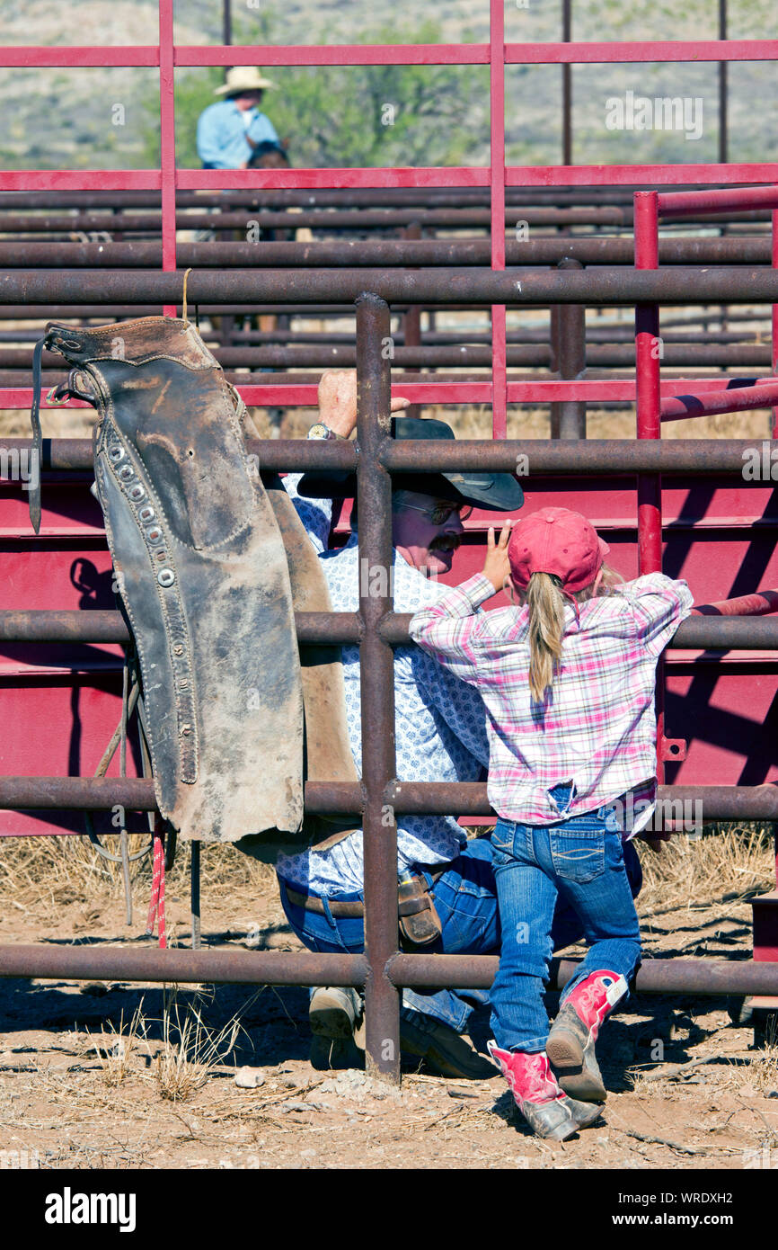 Niña hablando con un vaquero, durante las operaciones de embarque en un rancho de Texas oeste. Foto de stock