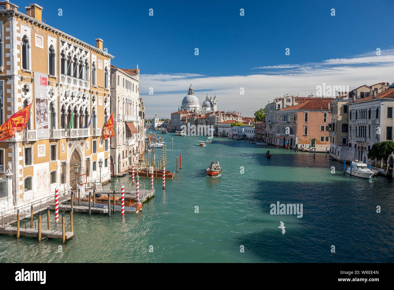 Vista del Gran Canal Venecia Italia en el sol con varios barcos en el canal Foto de stock