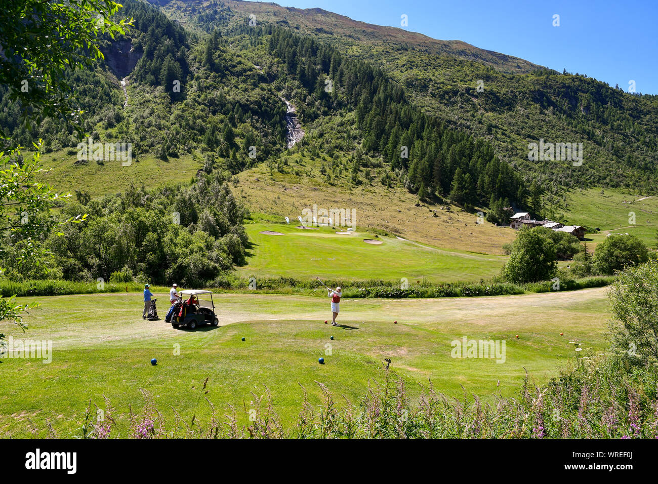 Vistas panorámicas del campo de golf Club Courmayeur et Grandes Jorasses en Val Ferret, con gente jugando al golf en verano, Courmayeur, Italia Foto de stock
